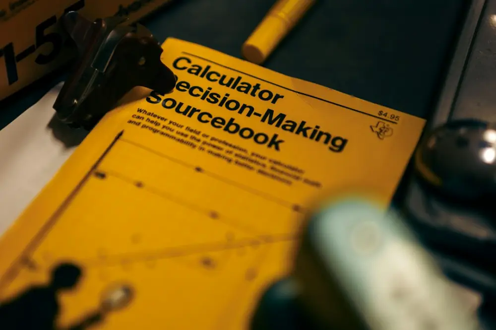 A calculator decision - making sourcebook with a calculator next to, illustrating leadership foundations